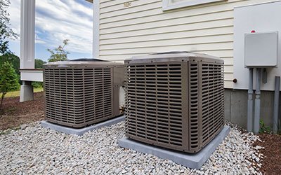 Two outdoor HVAC condenser units installed on concrete pads